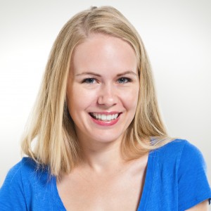 Smiling woman with blonde hair wearing a blue top, professional headshot against a light background.